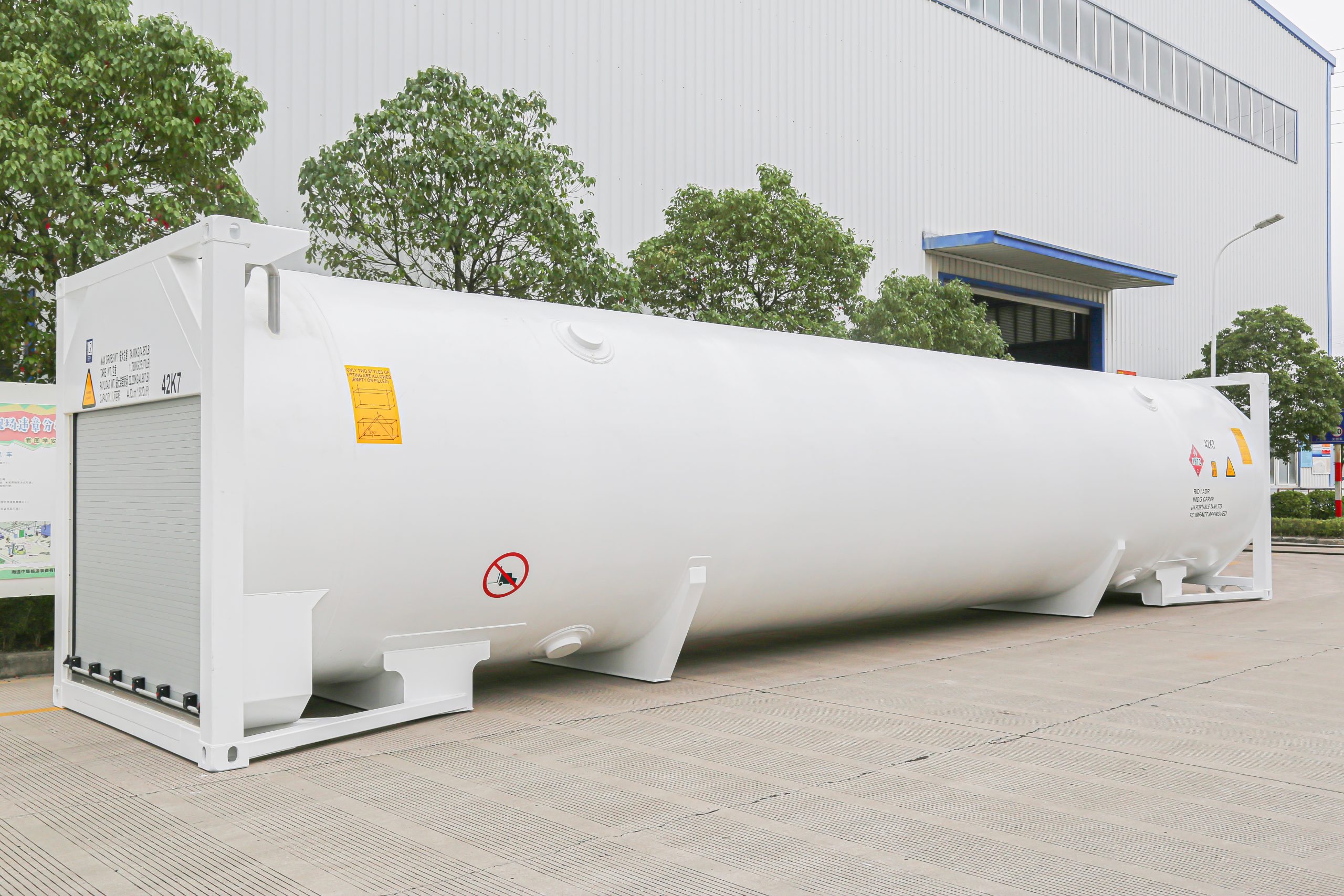 White ISO tank container in front of a building